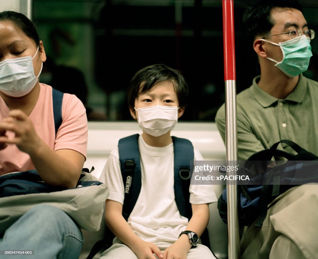 Boy (8-9) wearing face mask on train