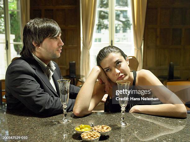 well-dressed couple sitting with empty champagne glasses at table - bored girlfriend stock pictures, royalty-free photos & images