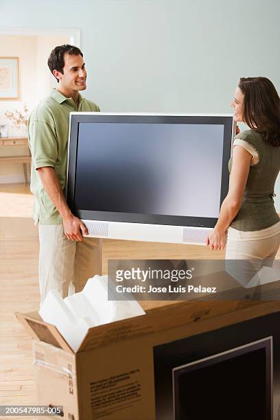 couple unpacking flat screen tv - box white flat stock-fotos und bilder