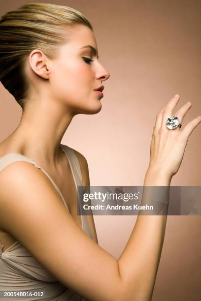 young woman looking at diamond ring, close-up - bling bling fotografías e imágenes de stock