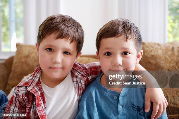 twin boys (6-7) sitting, smiling, close-up, portrait - twins boys stockfoto's en -beelden