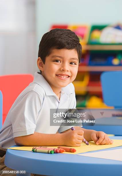 boy (4-5) using colour pencils, smiling, portrait - kid holding crayons stock pictures, royalty-free photos & images