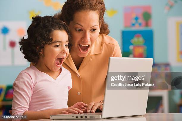 teacher with schoolgirl (6-7), using laptop, mouth open, close-up - pedagoga imagens e fotografias de stock