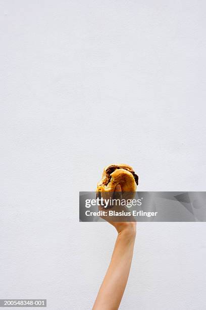 teenage boy (13-14) holding a bitten hamburger - burger bildbanksfoton och bilder