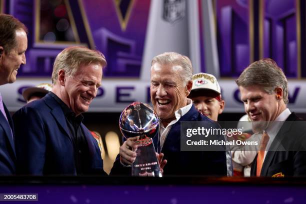 Commissioner Roger Goodell and NFL Hall-of-Famer John Elway react as they look at the Vince Lombardi Trophy following the NFL Super Bowl 58 football...