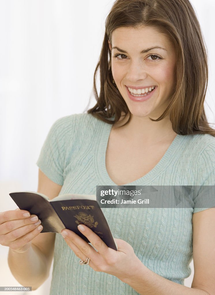 Young woman with passport, smiling, portrait, close-up