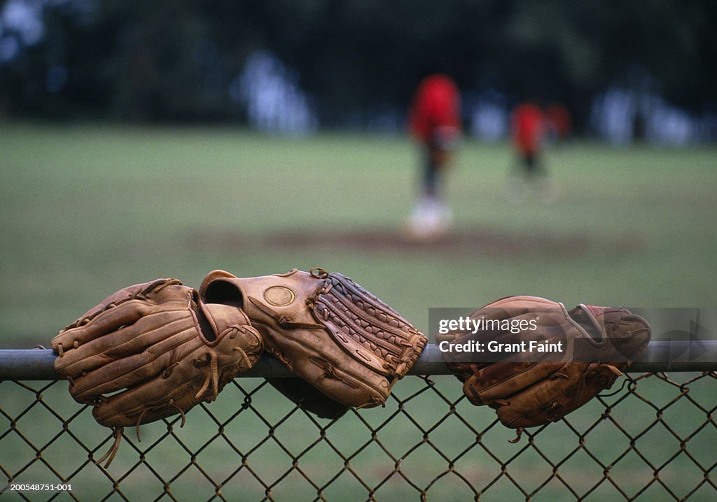 Baseball gloves on wire mesh fence