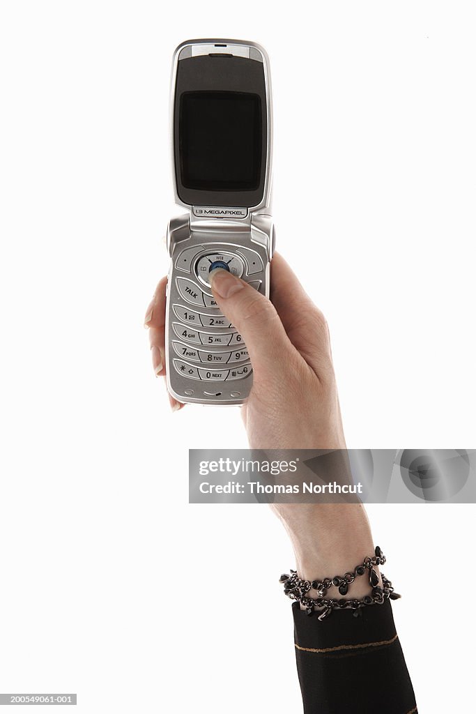 Woman using cell phone, close-up of hand