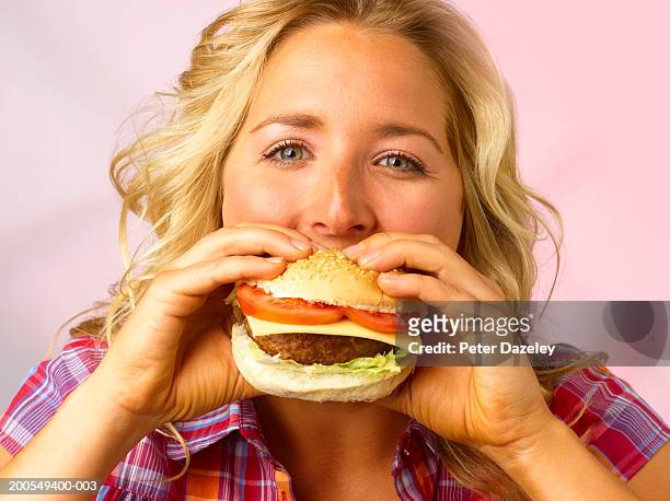 young woman eating burger, close-up, portrait - burger portrait photos et images de collection