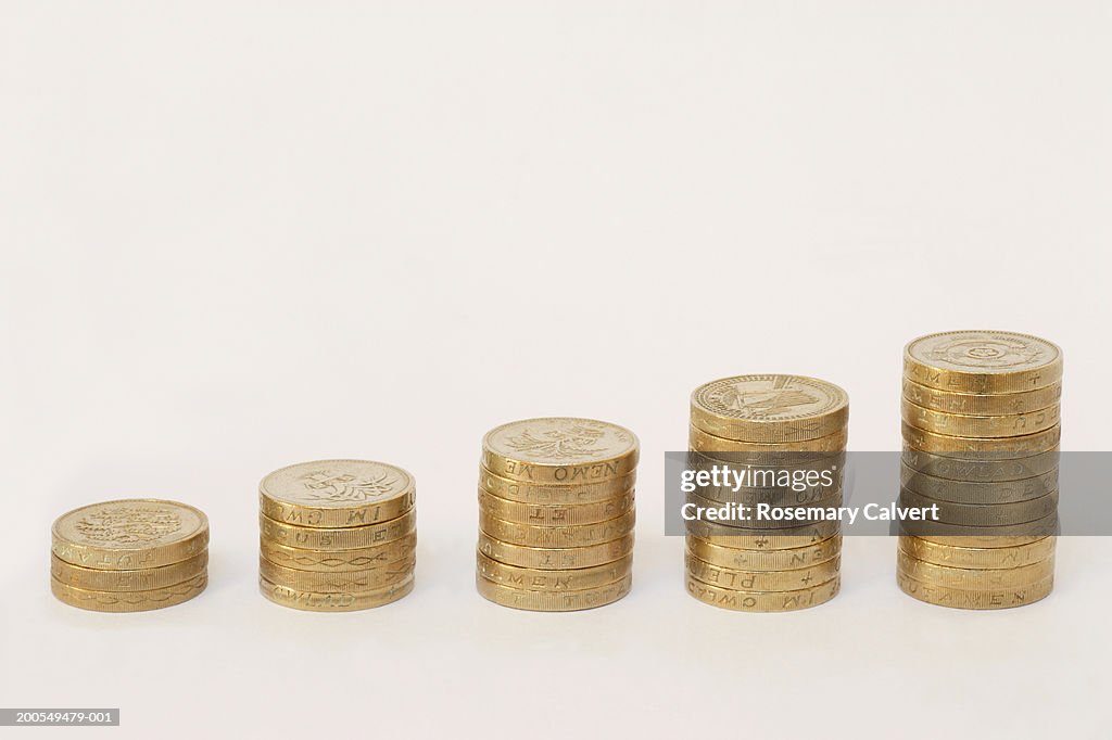 Stacks of one pound coins in increasing heights, close-up