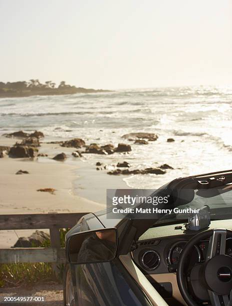 convertible car parked over looking beach - big sur coast stock pictures, royalty-free photos & images