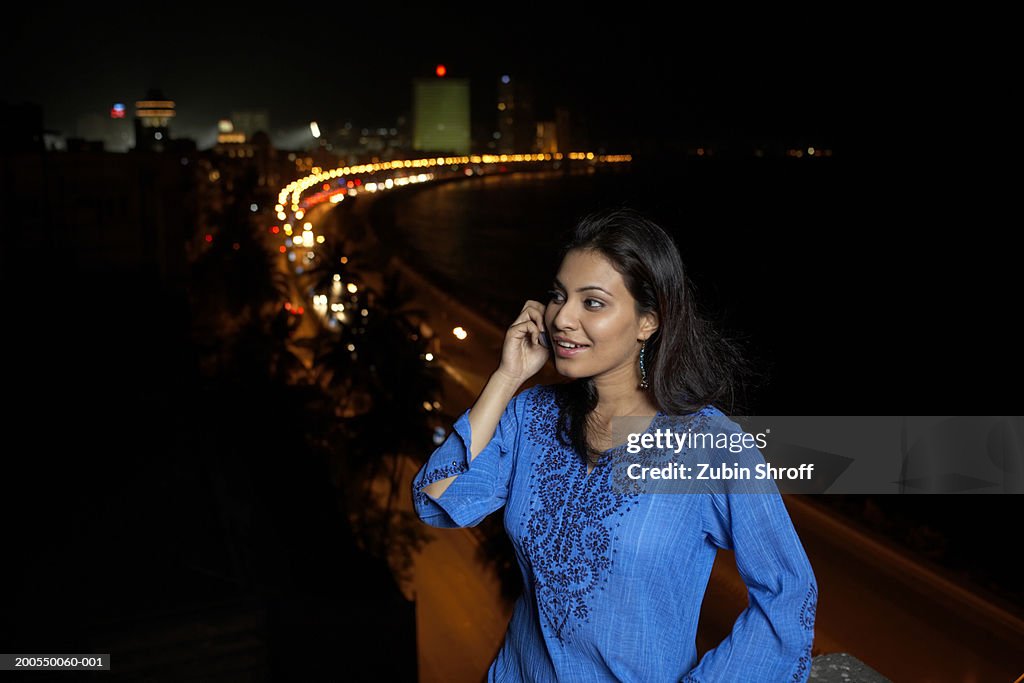 Young woman using mobile phone, night