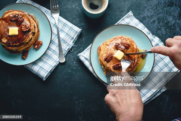 stack of sweet potato pancakes with butter and pecan nuts - sweet potato pancakes stock pictures, royalty-free photos & images