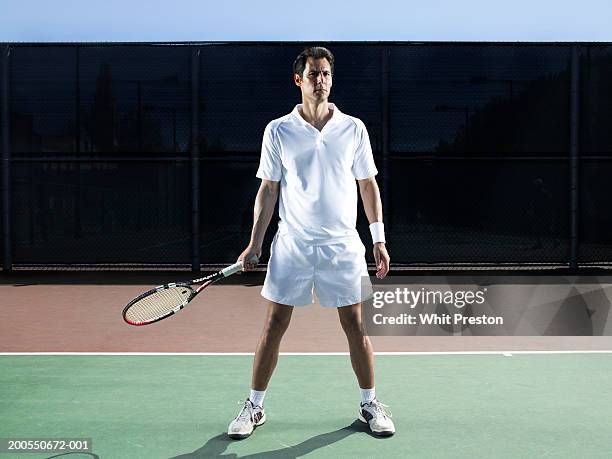 man holding tennis racket on court - holding tennis racquet stock pictures, royalty-free photos & images