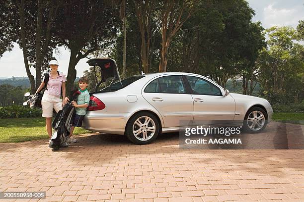 mother with son (10-11) at golf clubs parking lot, portrait - golf bag stock pictures, royalty-free photos & images