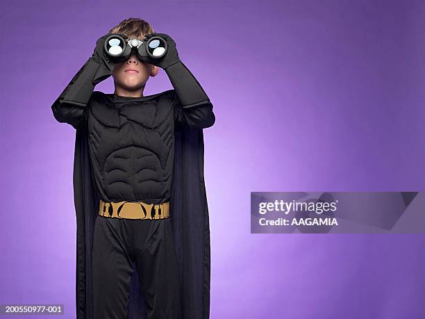 boy (10-11) in super hero costume looking through binoculars - superman reveal stock pictures, royalty-free photos & images