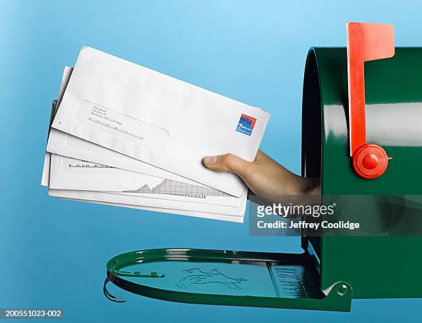 young woman holding mail out of mailbox, side view - post stock-fotos und bilder