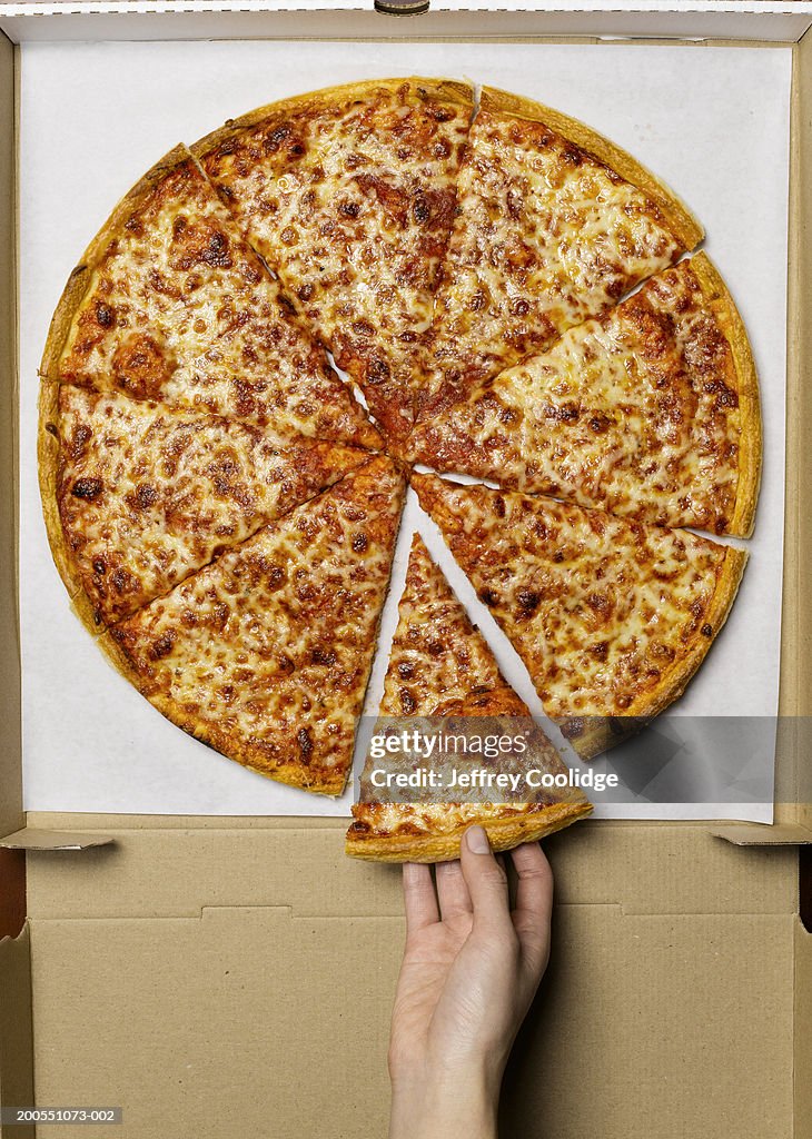 Young woman taking slice of pizza, overhead view