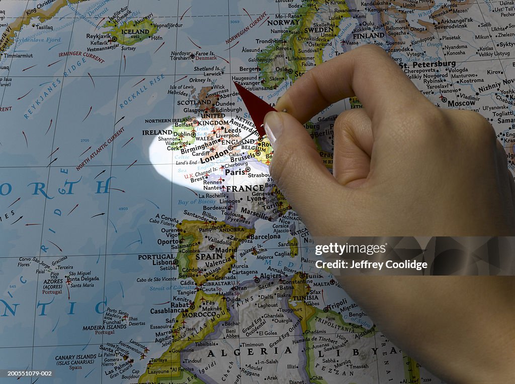 Young woman placing pin on London on map