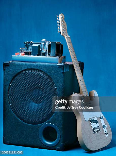 electric guitar leaning on tube amplifier. - guitar amp stock-fotos und bilder