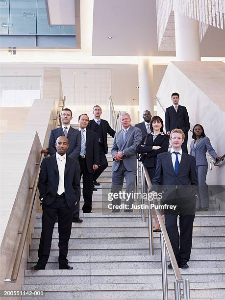businesspeople standing on stairway, smiling, portrait, low angle view - group of businesspeople standing low angle view stock pictures, royalty-free photos & images