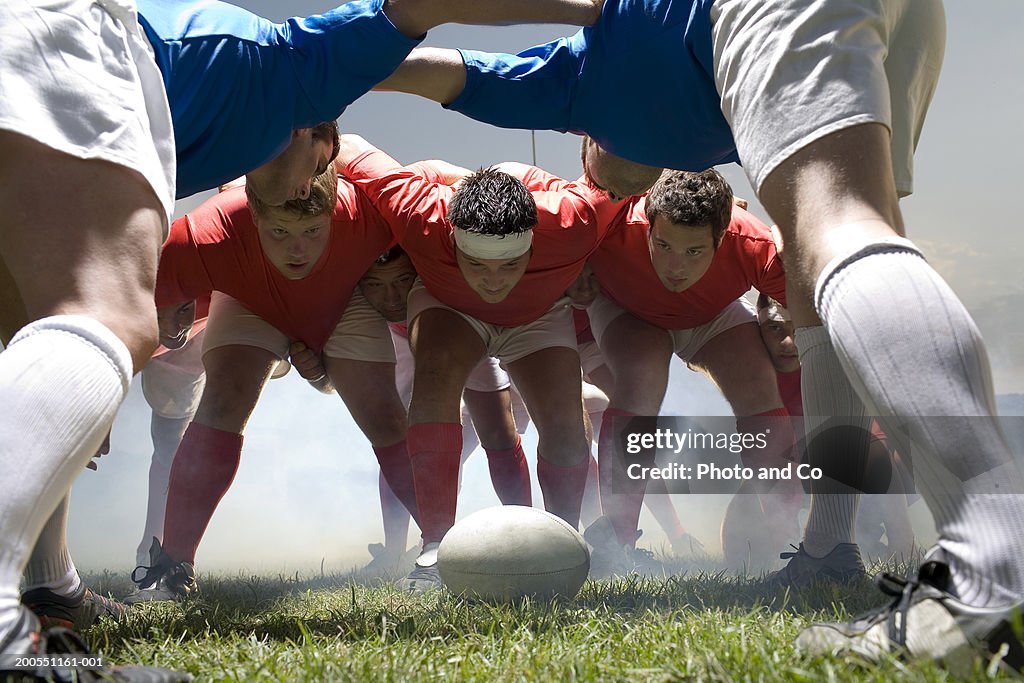 Young rugby players forming scrum in field