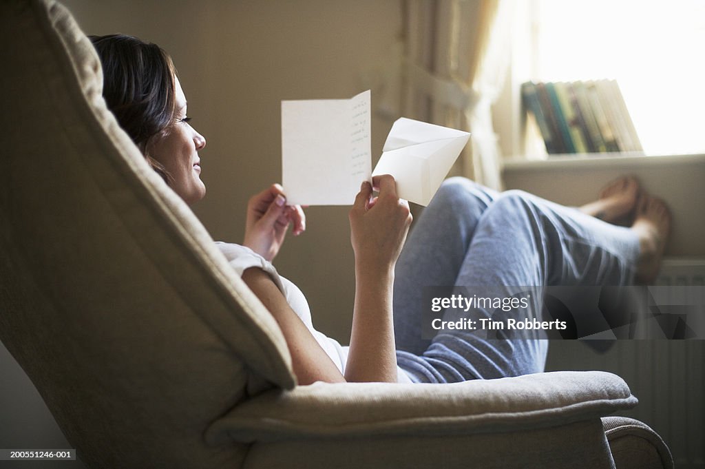 Young woman reading letter and smiling