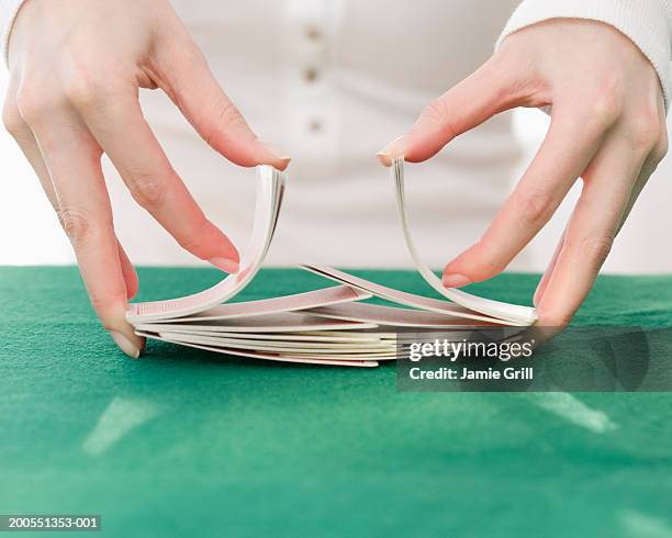 woman shuffling deck of cards, close-up - barajar fotografías e imágenes de stock