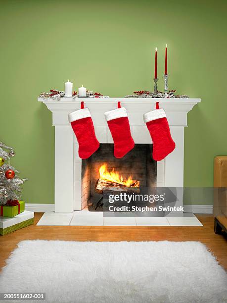 christmas stockings hanging over fireplace - fireplace fotografías e imágenes de stock