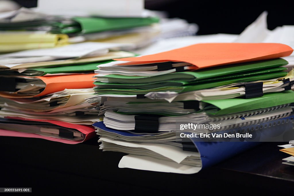 Stacks of notepads and organizers on desk, close-up