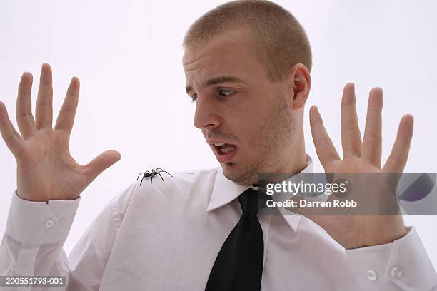 young businessman with spider on shoulder, close-up - phobia fotografías e imágenes de stock