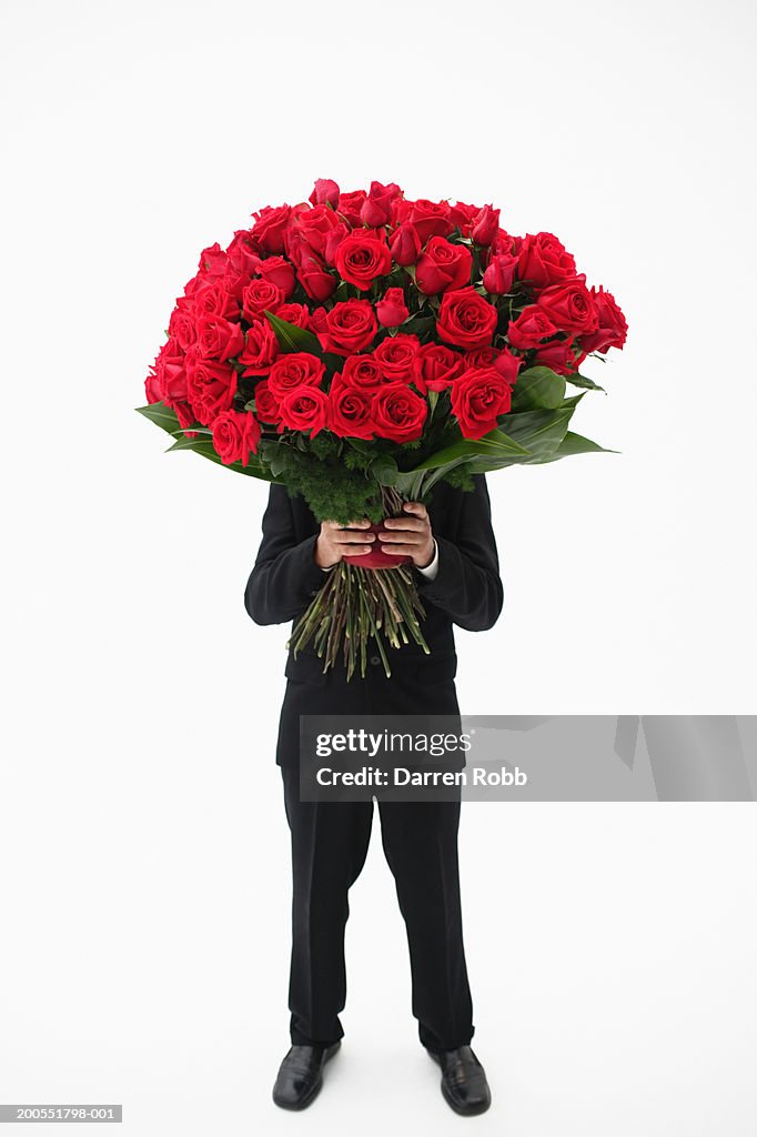 Businessman holding bouquet of red roses