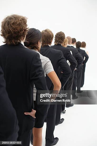 group of young businesspeople standing in line, rear view - gente en fila fotografías e imágenes de stock