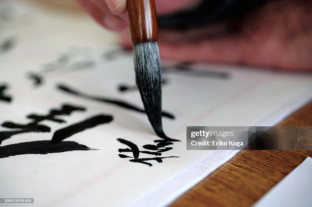 Man doing calligraphy, selective focus, close-up