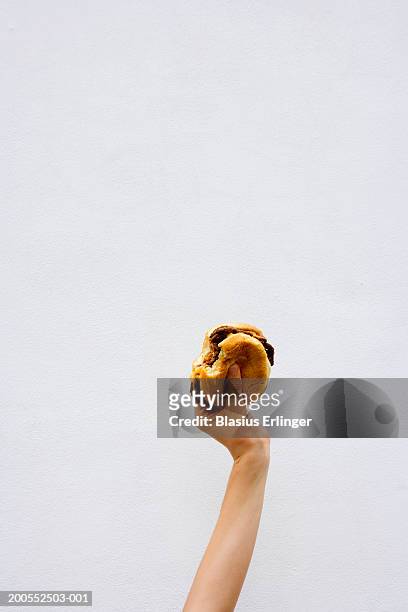 teenage boy (13-14) holding bitten hamburger - hand holding burger stock pictures, royalty-free photos & images