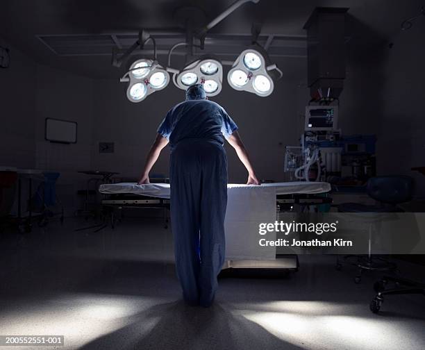 surgeon in operating room, rear view - operationssaal stock-fotos und bilder