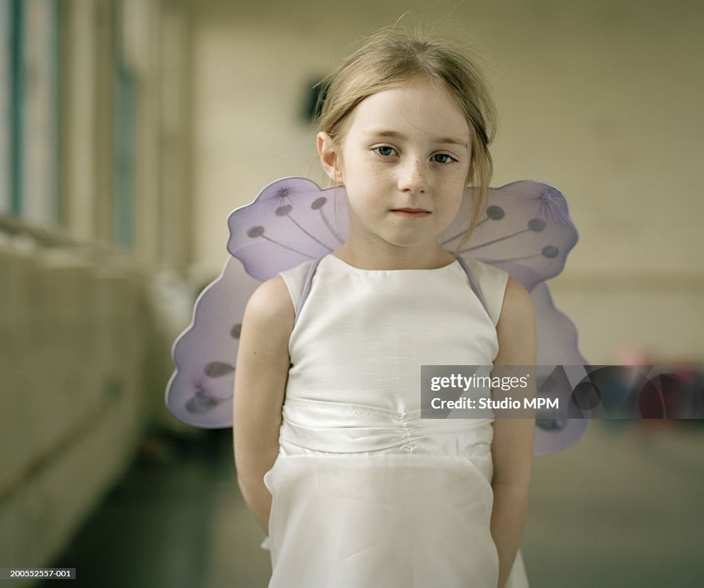 Girl (6-7) in fairy costume, smiling, portrait