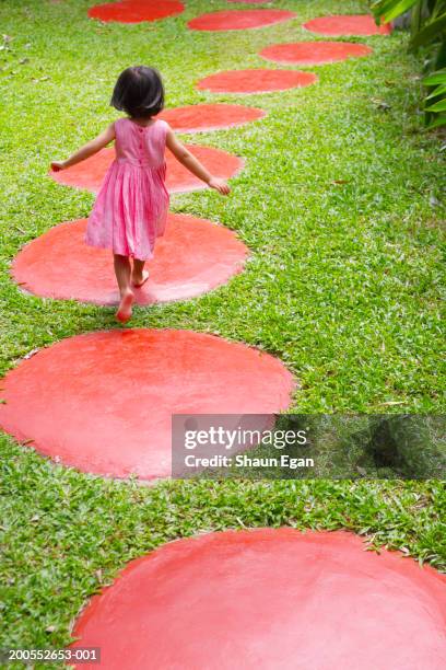 girl (3-4) walking on red stepping stones, rear view - stepping stone top view stock pictures, royalty-free photos & images