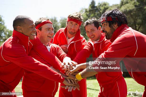 group of men stacking hands on top of each other - sweat band stock pictures, royalty-free photos & images