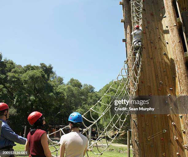 men and women waiting to go through rope ladder obstacle - scala di corda foto e immagini stock