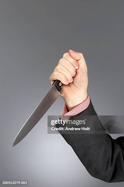 businessman in suit holding kitchen knife, close-up of hand - knife crime stock-fotos und bilder