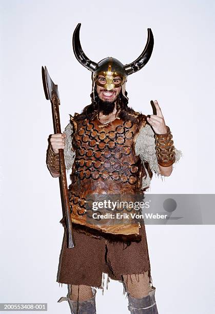 young man in viking costume against white background, smiling, portrait - vikings stock-fotos und bilder