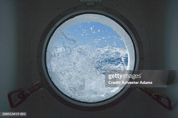 view from cabin porthole with water splashing on it - bullauge stock-fotos und bilder
