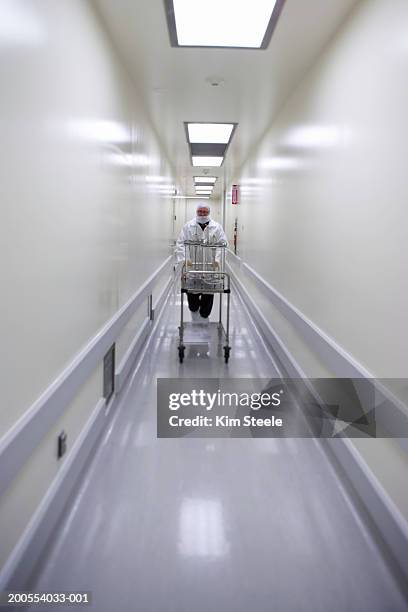 scientist with transferring bioreactors down clean corridor - hospital cart stock pictures, royalty-free photos & images