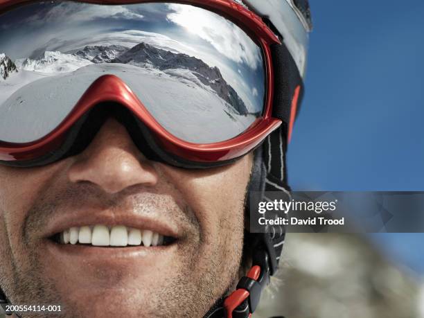 man wearing ski goggles, smiling, close-up - occhiali da sci foto e immagini stock