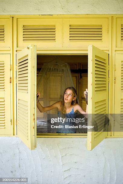 girl (12-13) looking out of shutter window - open day 13 stock pictures, royalty-free photos & images