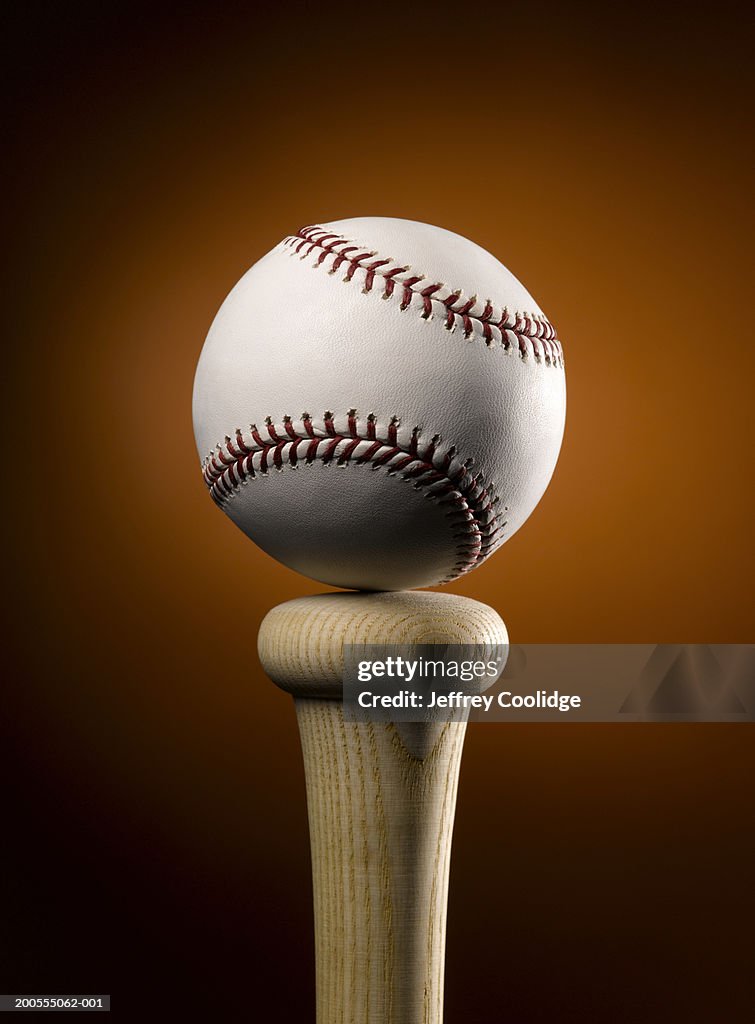 Baseball balancing on top of bat, close-up