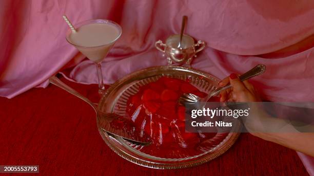 red jelly cake filled with hearts and hand with spoon - red jelly stock pictures, royalty-free photos & images