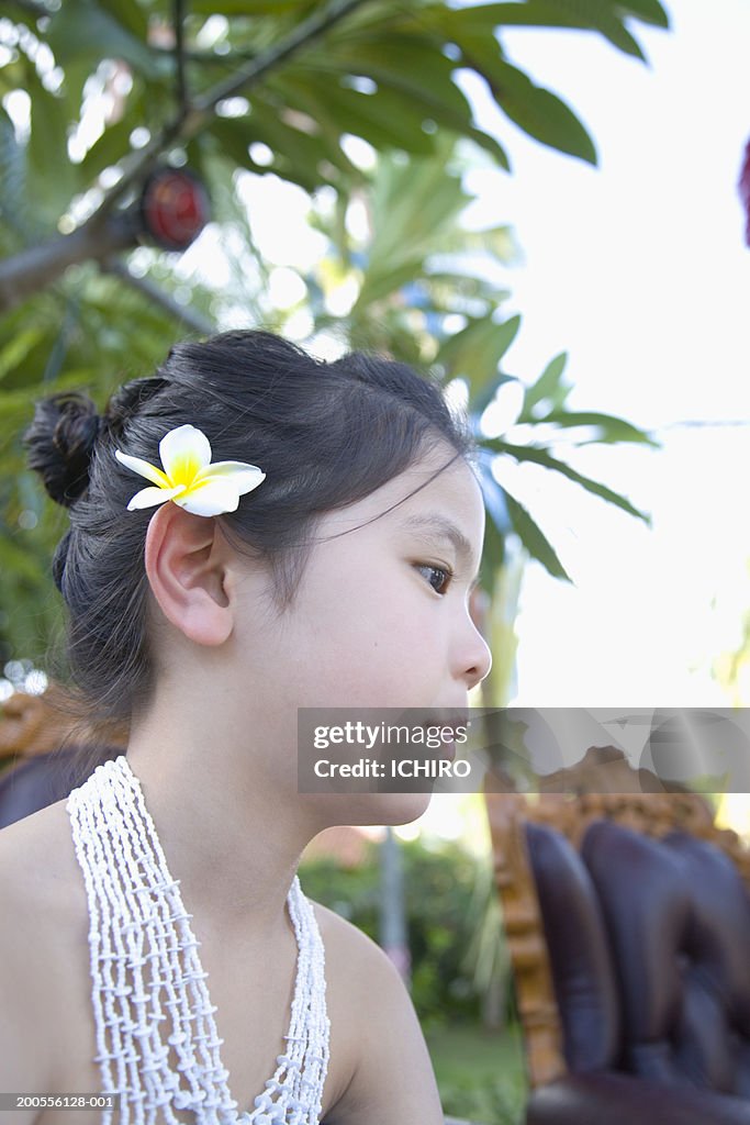 Girl (8-9) with flower in hair, profile, close-up