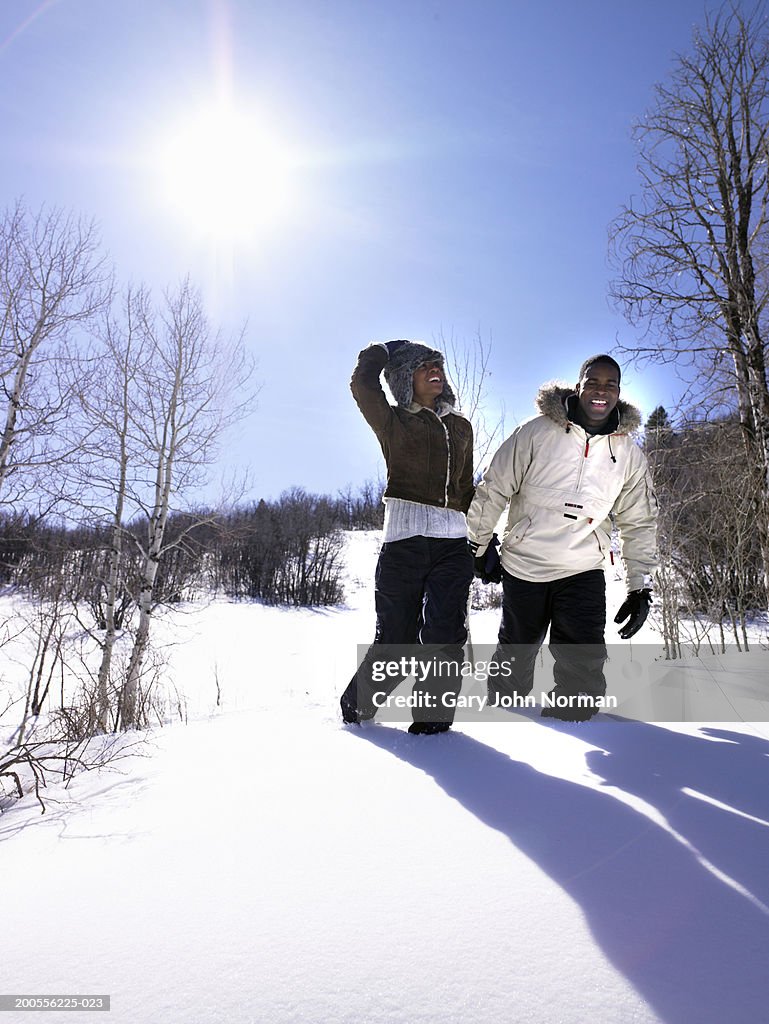 Couple walking in snow, three quarter length